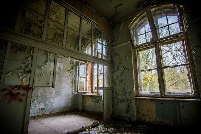 Ein Zimmer mit einem zerbrochenen Fenster und einer Wand aus Farbe